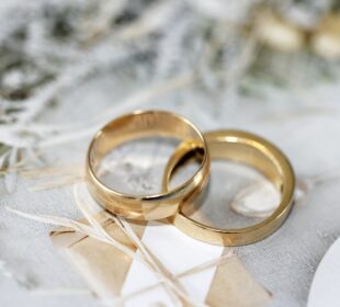 gold wedding band on white textile