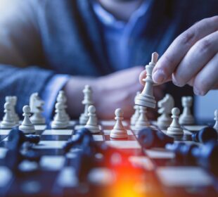 depth of field photography of man playing chess