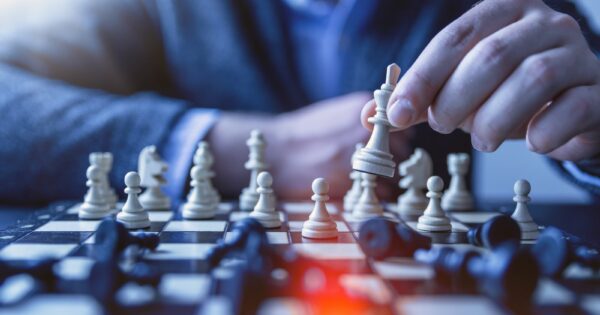 depth of field photography of man playing chess