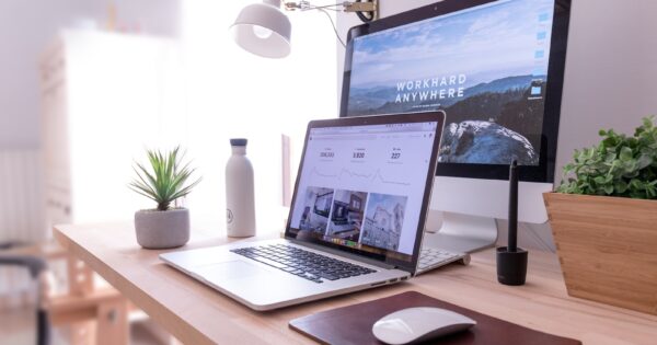 MacBook Pro on table beside white iMac and Magic Mouse