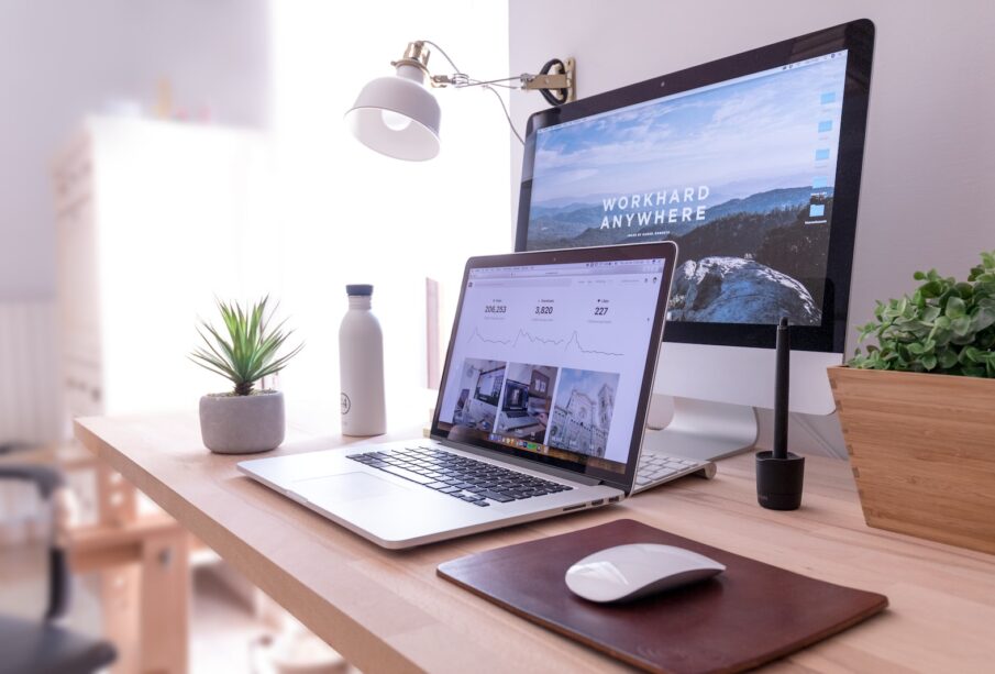 MacBook Pro on table beside white iMac and Magic Mouse